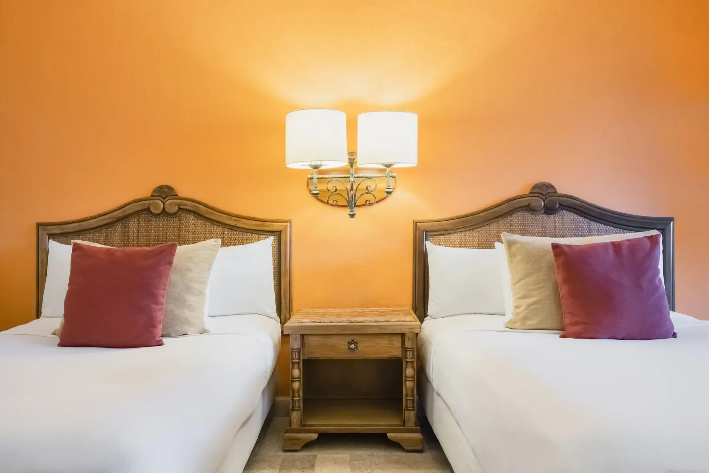 Two double beds in a Junior Suite at Iberostar Waves Paraíso Beach with warm orange wall lighting.
