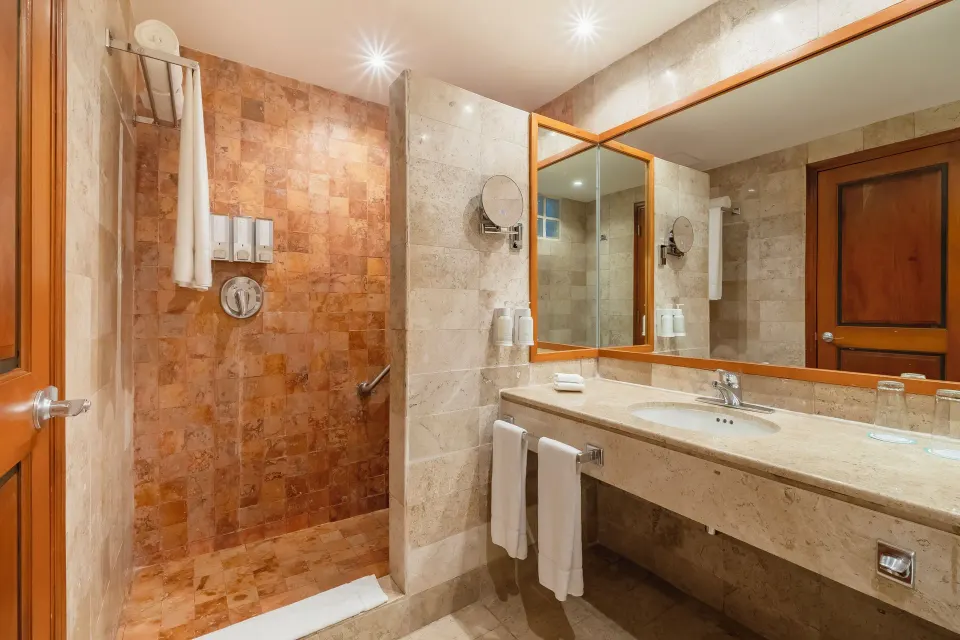 Junior Suite Beachside bathroom with shower and vanity at Iberostar Waves Paraíso Beach.