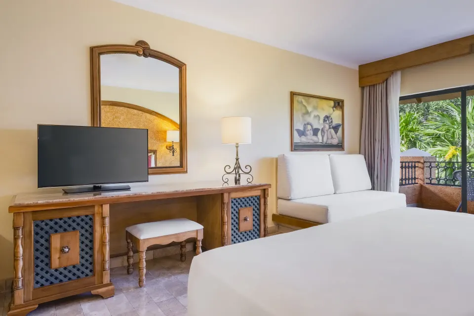 Premium Room Poolside seating area and bed at Iberostar Waves Paraíso Beach.