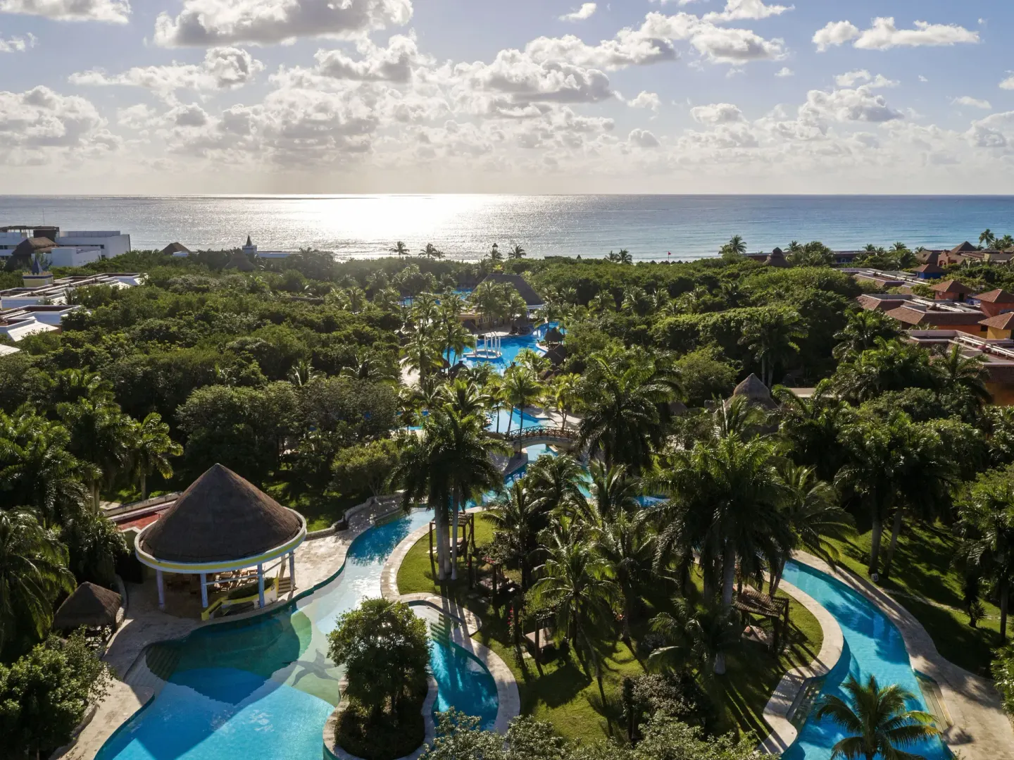 Aerial resort view with pools, palms, and ocean at Iberostar Waves Paraíso del Mar.