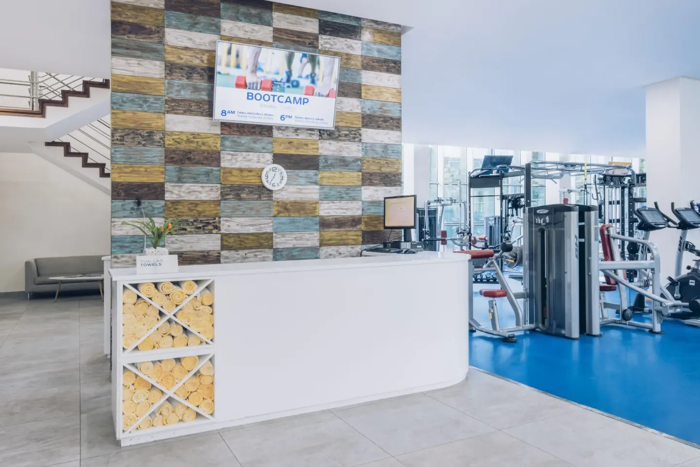 Gym reception desk with towel cubbies and equipment beyond at Iberostar Waves Paraíso del Mar.