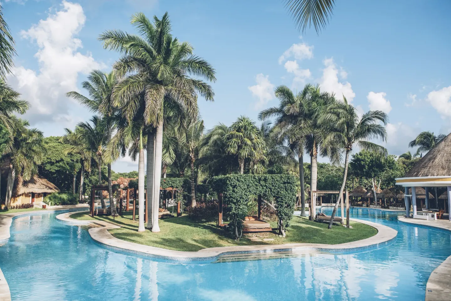 Lagoon-style pool around palm islands at Iberostar Waves Paraíso del Mar.