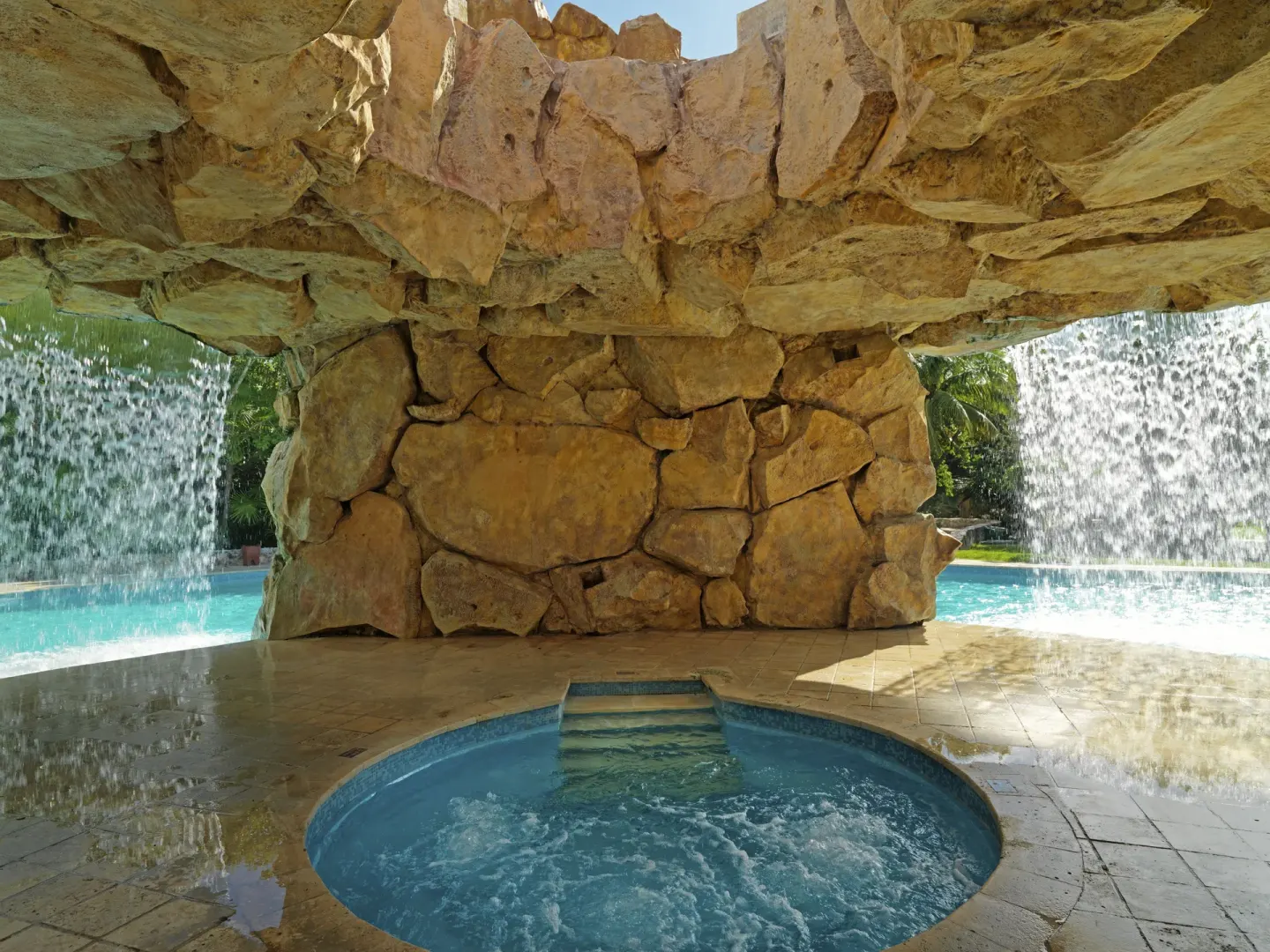 Circular whirlpool beneath rockwork and waterfalls at Iberostar Waves Paraíso del Mar.