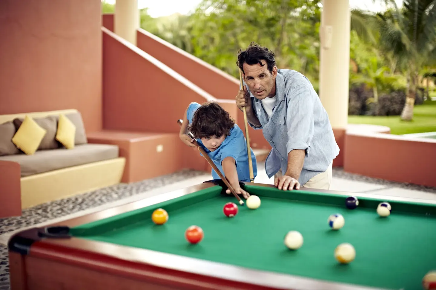 Guests play billiards in a shaded game area at Iberostar Waves Paraíso del Mar.