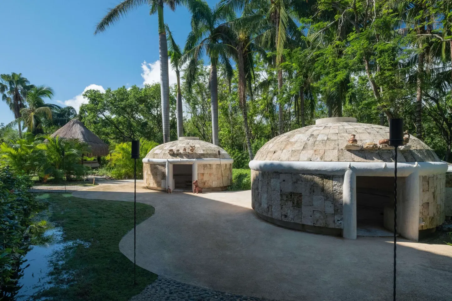 Stone spa huts set among palms at Iberostar Waves Paraíso del Mar.