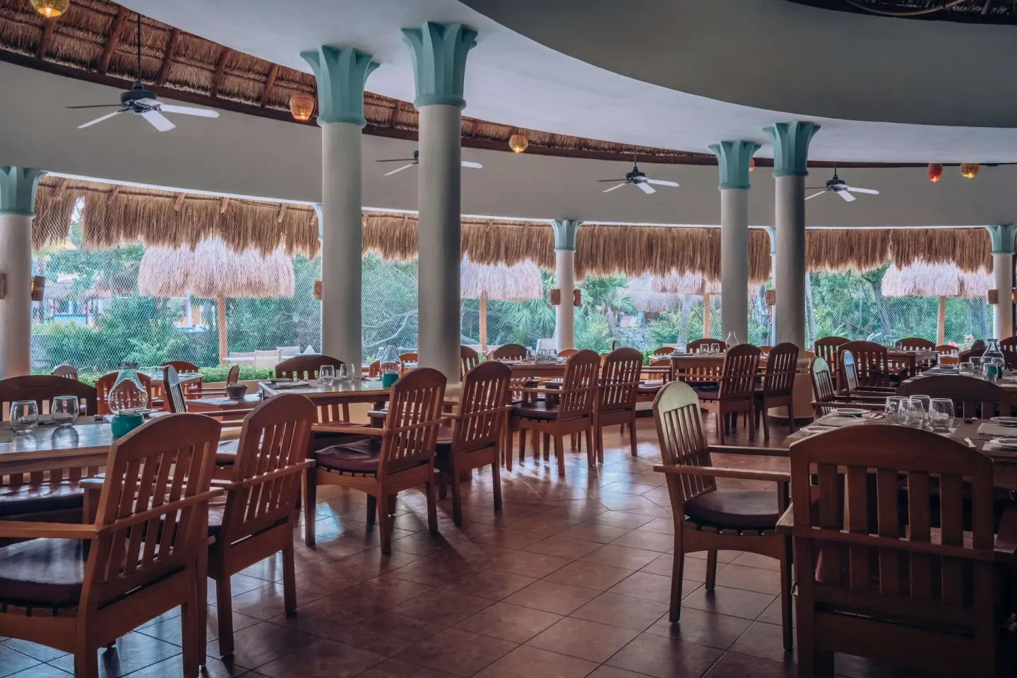 Open-air restaurant seating under a thatched roof at Iberostar Waves Paraíso del Mar.