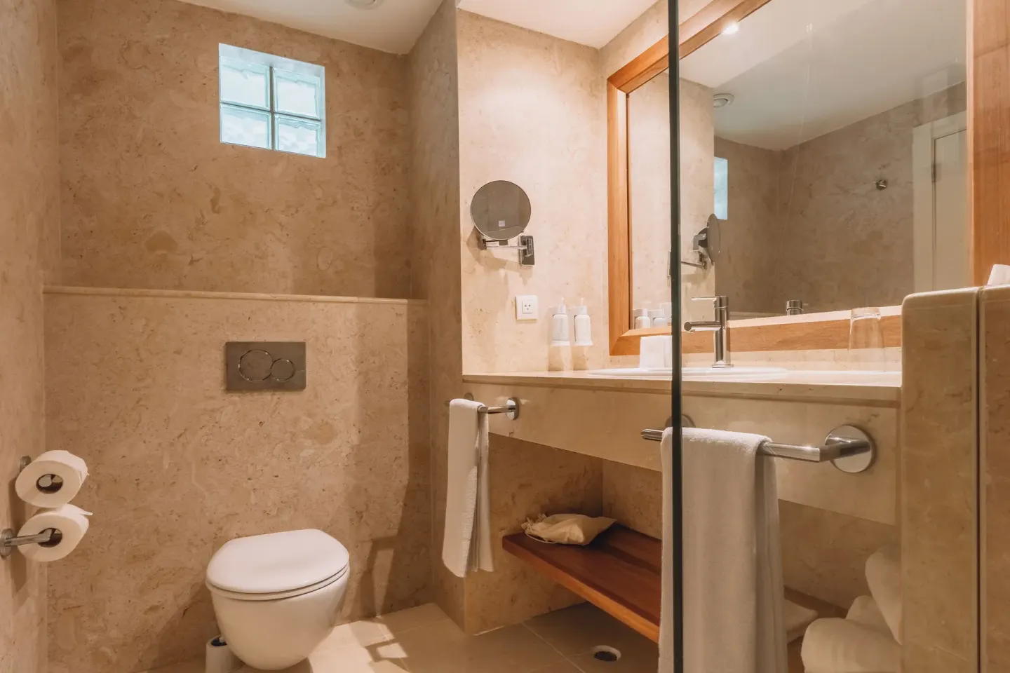 Bathroom with vanity mirror and toilet at Iberostar Waves Punta Cana.