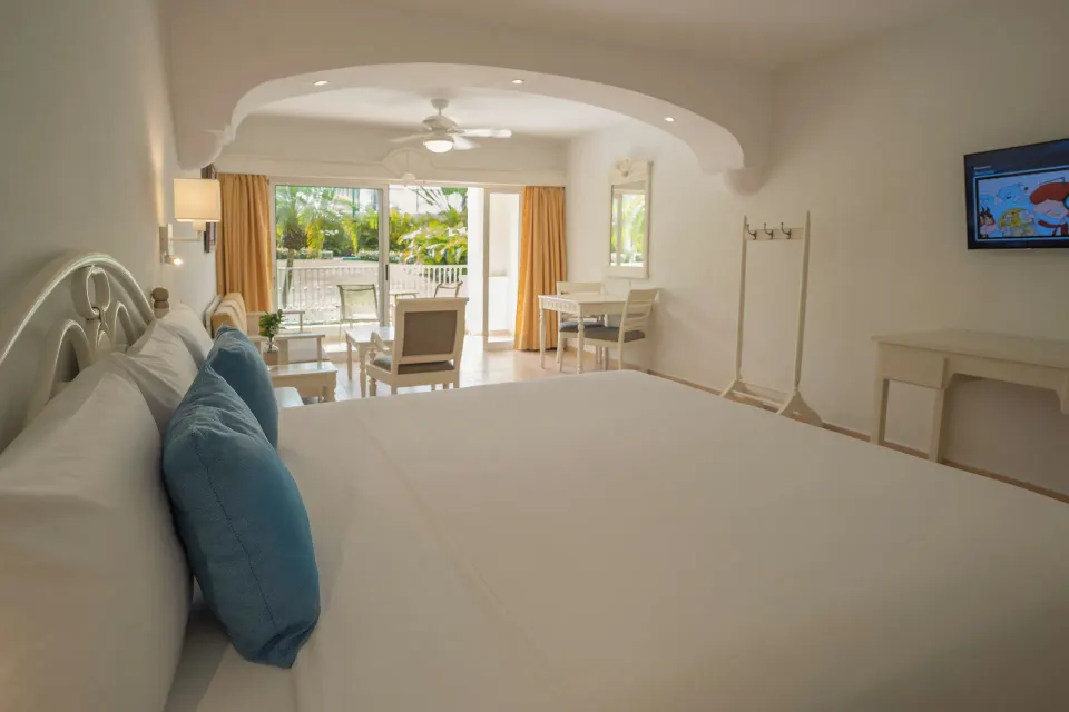 King bed and sitting area with balcony doors at Iberostar Waves Punta Cana.