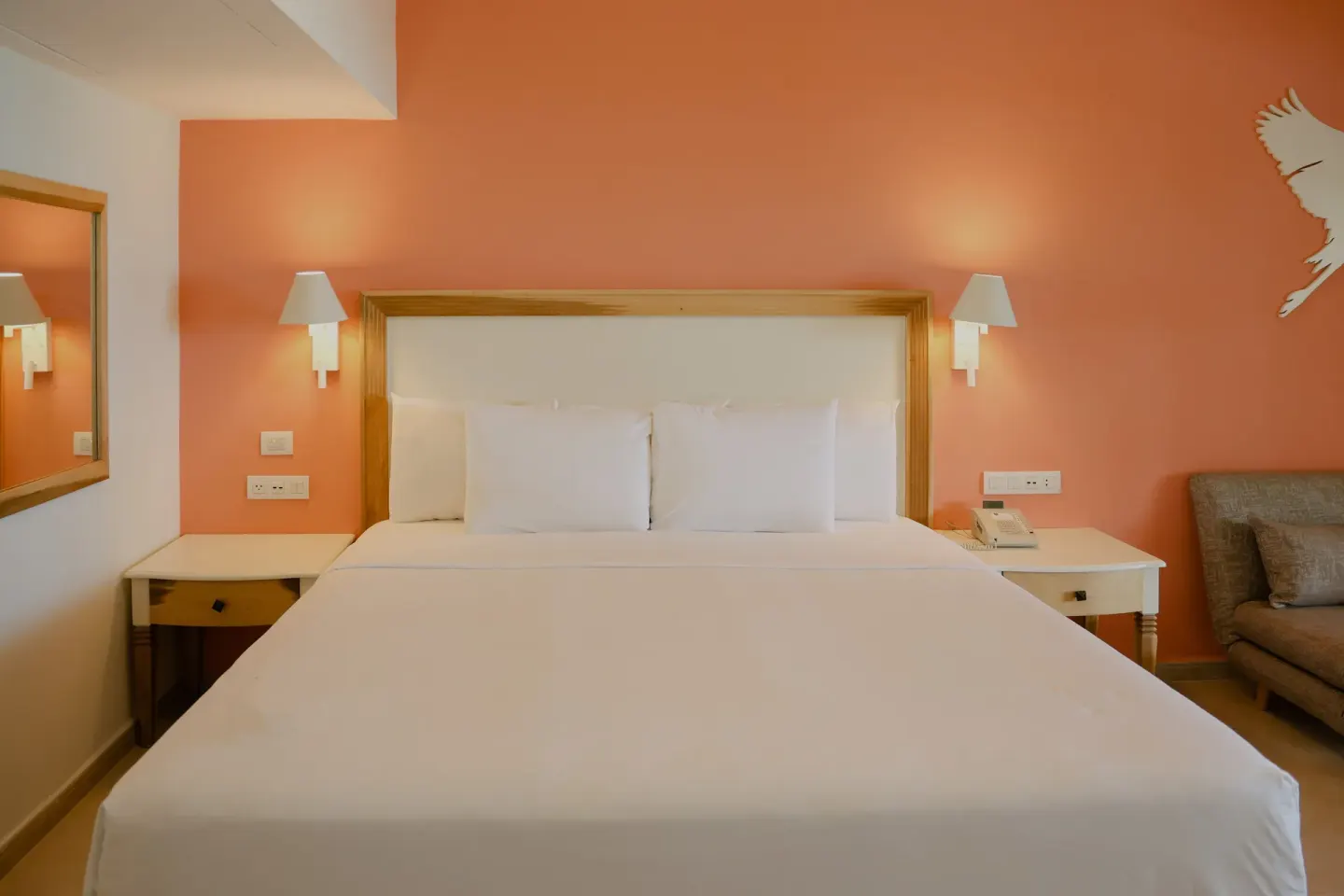 King bed guest room with coral accent wall at Iberostar Waves Punta Cana.