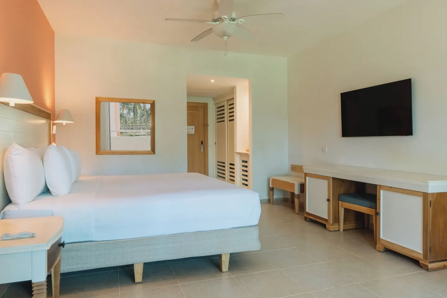 King bed room with desk, TV and ceiling fan at Iberostar Waves Punta Cana.