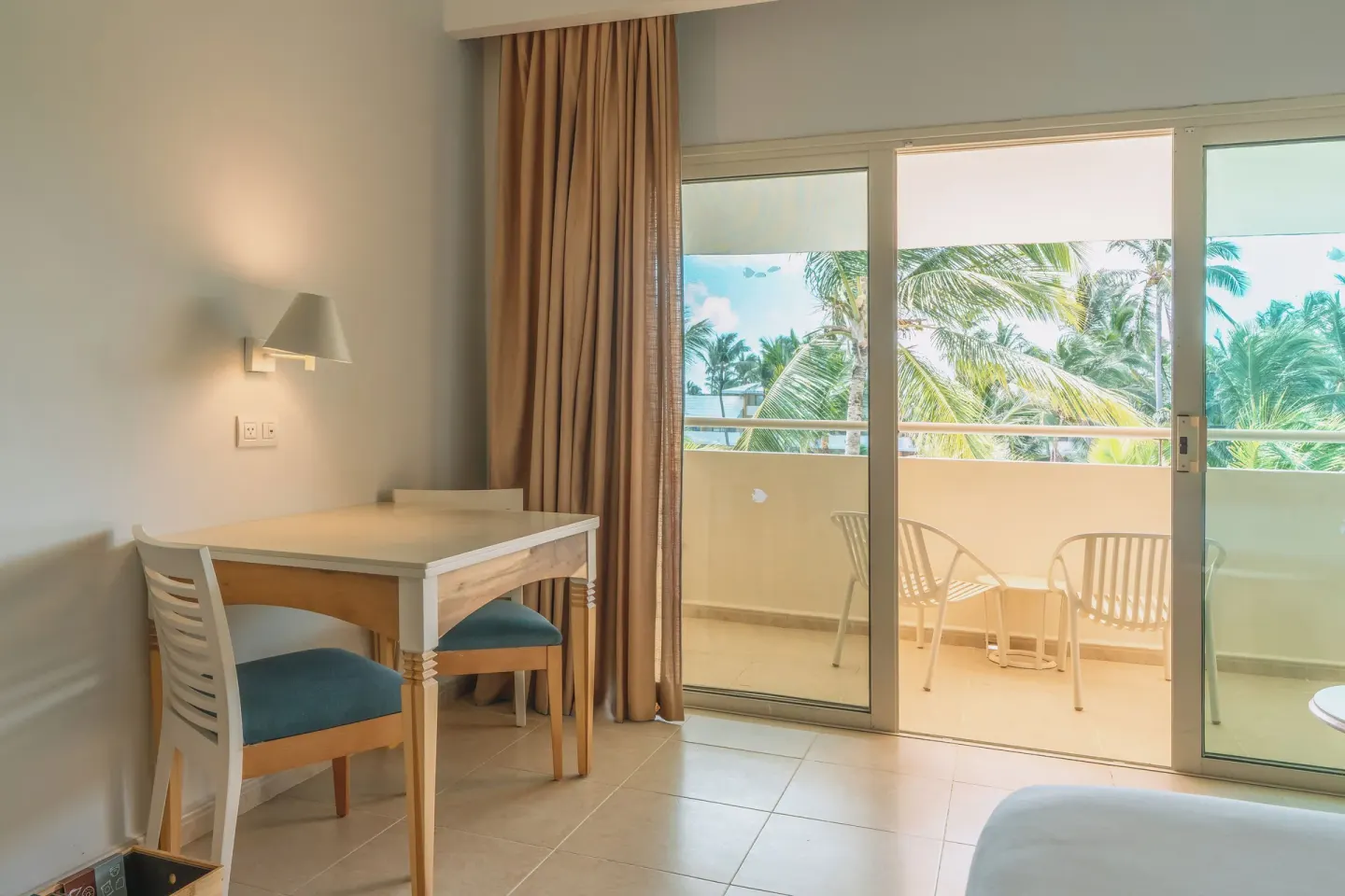 Guest room sitting area and balcony doors at Iberostar Waves Punta Cana.