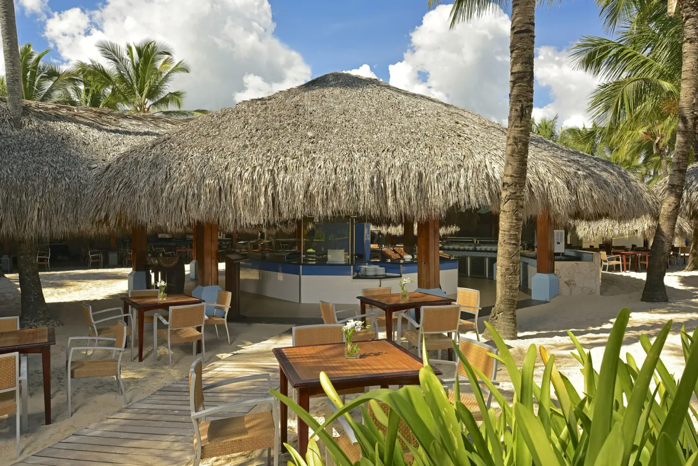 Thatched beachside dining area with tables at Iberostar Waves Punta Cana.