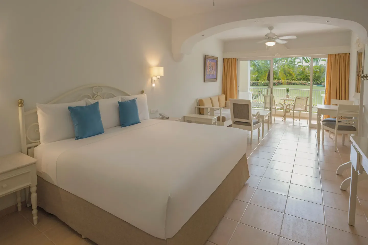 Junior Suite king bed with balcony seating at Iberostar Waves Punta Cana.