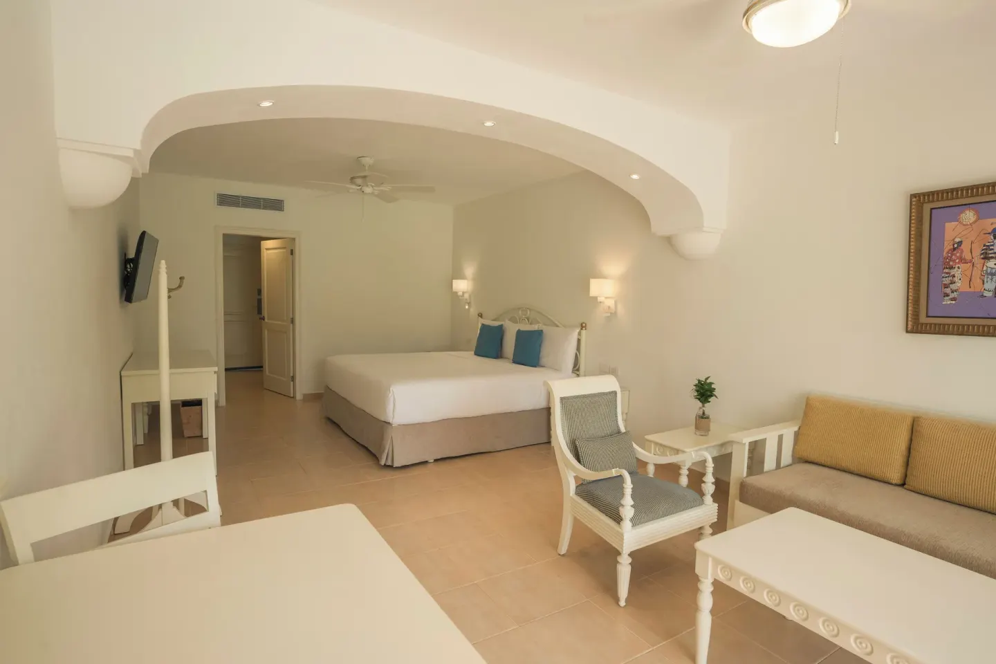 Junior Suite room with king bed and seating area at Iberostar Waves Punta Cana.