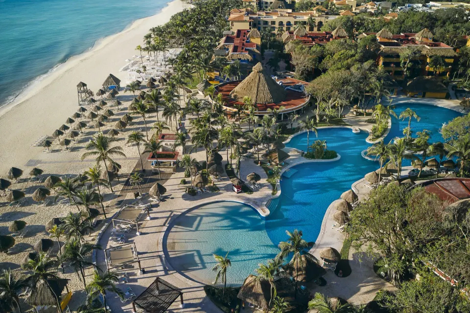 Aerial view of pools, palapas and beach at Iberostar Waves Tucán resort.
