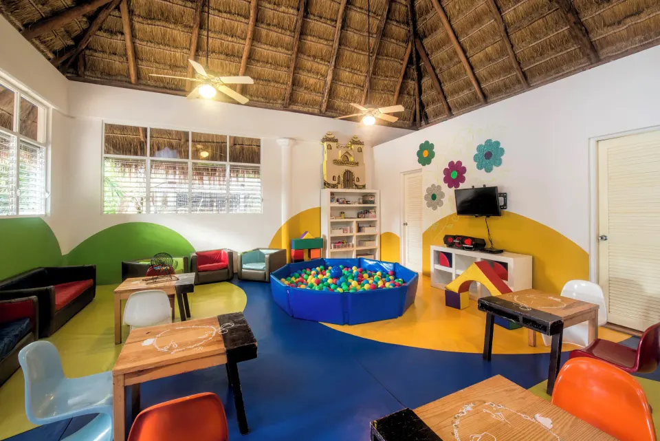 Wide view of children's playroom with ball pit and colorful chairs at Iberostar Waves Tucán