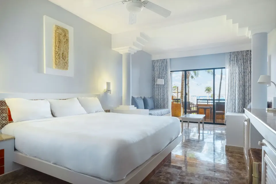 Large bright room with a king bed and balcony view at Iberostar Waves Tucán