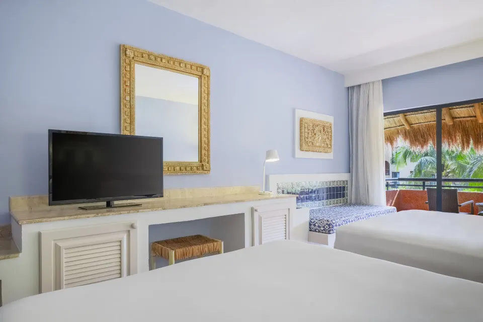 Bright guest room with two beds, TV and balcony at Iberostar Waves Tucán