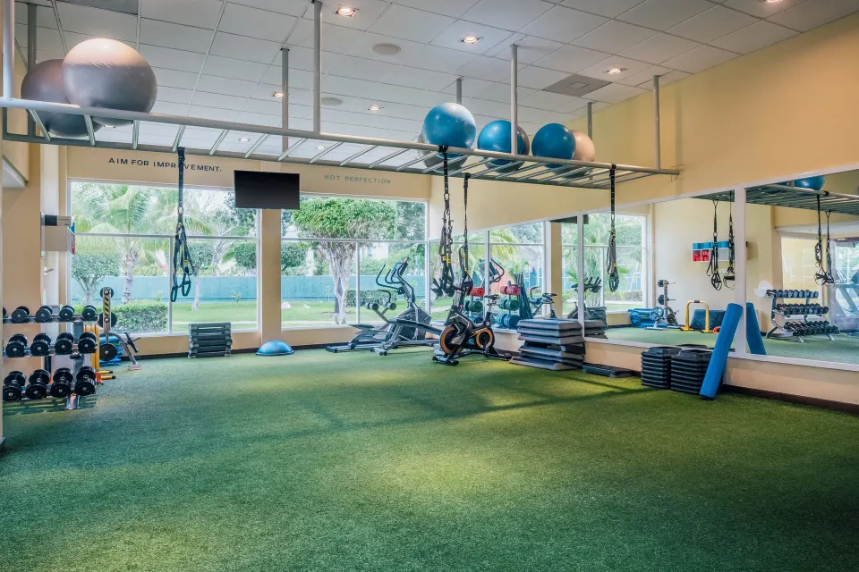 Resort exercise studio with turf area, cardio machines and fitness props at Iberostar Waves Tucán