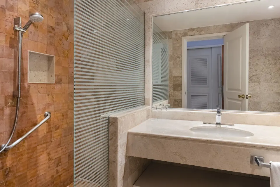 Shower with grab bar and marble sink in guest bathroom at Iberostar Waves Tucán