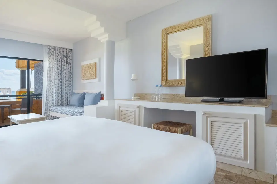 Bright guest room with king bed, TV and balcony at Iberostar Waves Tucán