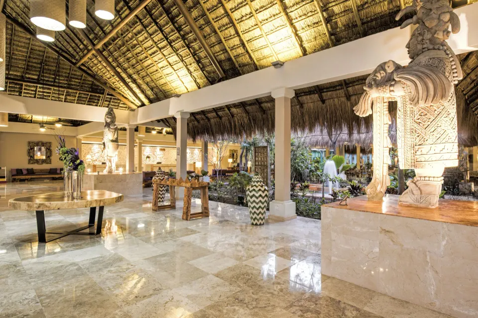 Lobby interior with decorative stone carvings and indoor fountain at Iberostar Waves Tucán