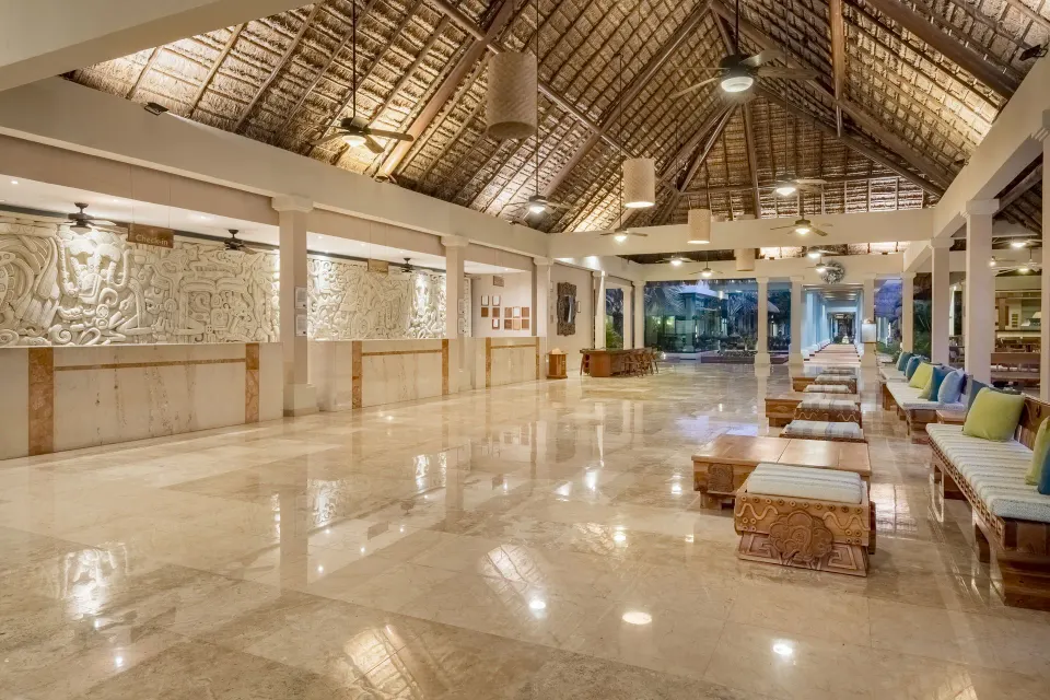 Wide lobby walkway with cushioned benches and marble floors at Iberostar Waves Tucán
