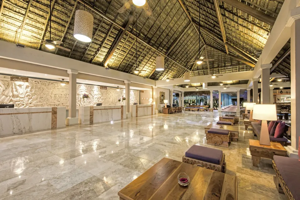 Spacious thatched-roof lobby with check-in counters and seating at Iberostar Waves Tucán