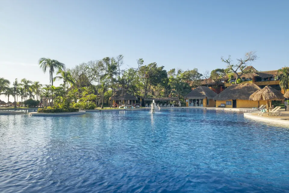 Wide view of the resort's main pool with fountain and island landscaping at Iberostar Waves Tucán
