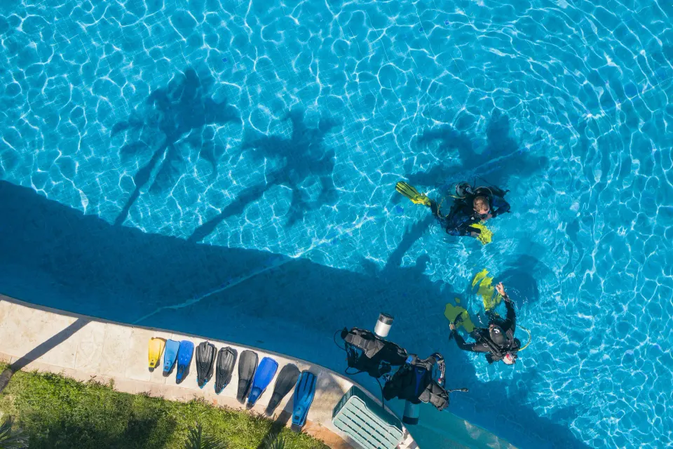 Scuba divers and flippers by the pool at Iberostar Waves Tucán