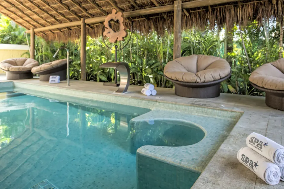 Private spa plunge pool with circular loungers and tropical planting at Iberostar Waves Tucán