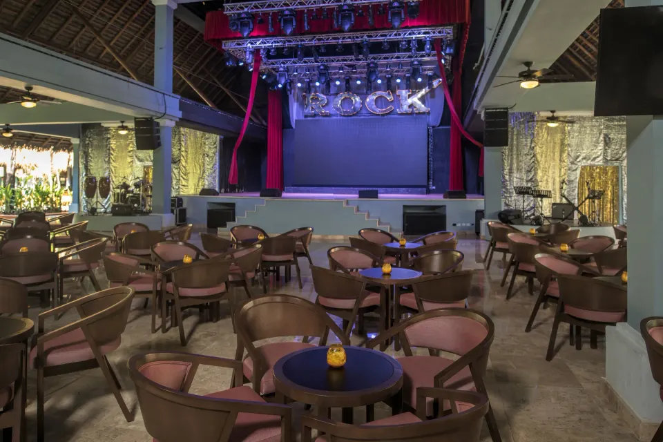 Indoor show stage and seating area with 'ROCK' letters at Iberostar Waves Tucán