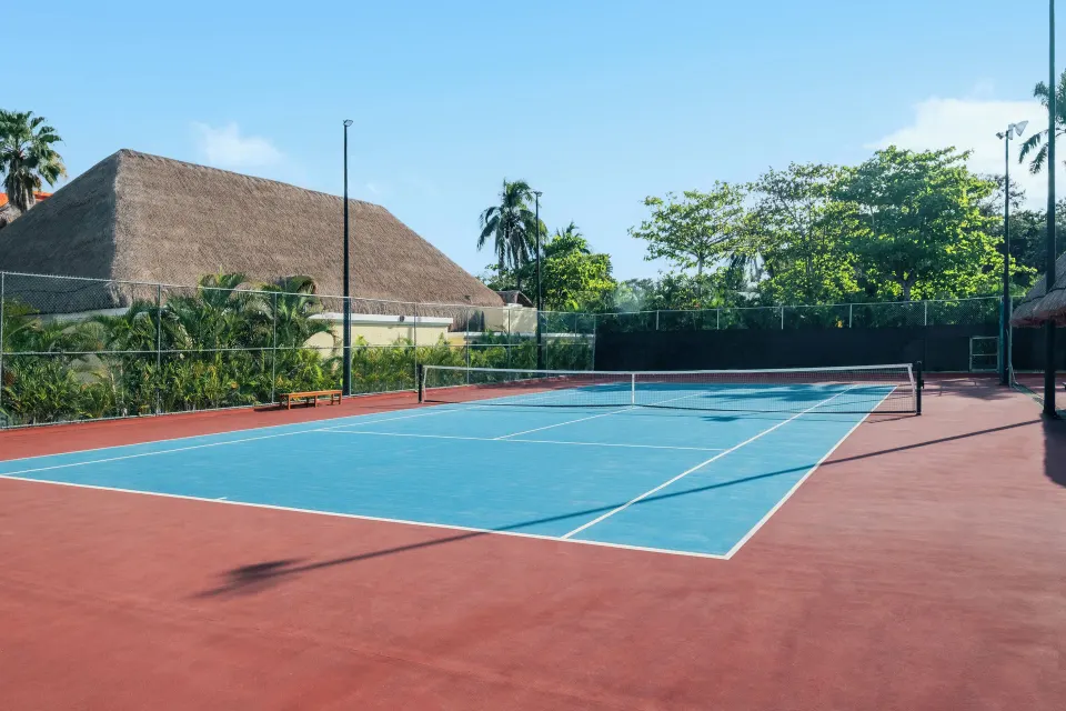 Outdoor tennis court with tropical landscaping at Iberostar Waves Tucán
