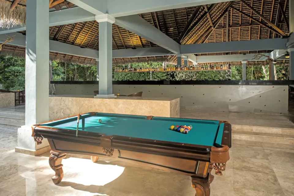 Pool table under a palapa roof at a recreational bar area at Iberostar Waves Tucán