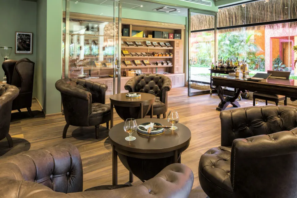 Leather lounge seating and small tables in the resort bar area at Iberostar Waves Tucán