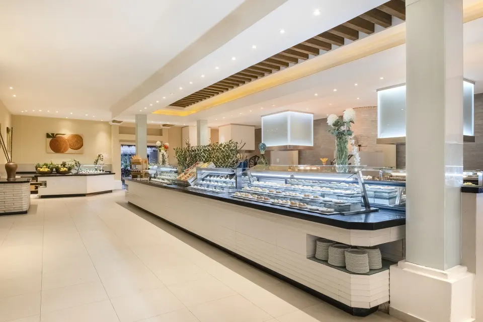 Long modern buffet island and serving counters in a bright dining room at Iberostar Waves Tucán