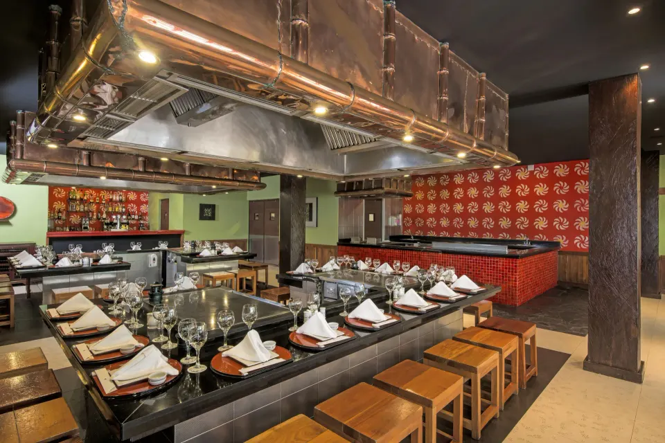 Teppanyaki-style dining tables and grill under copper hoods at Iberostar Waves Tucán
