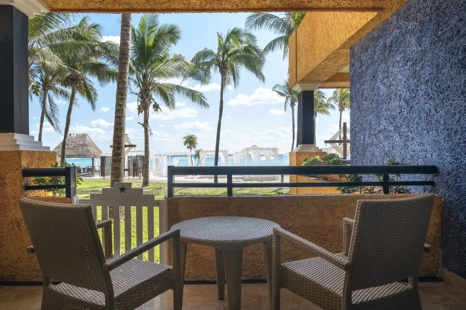 Junior Suite patio with table and chairs looking out to the beach at Iberostar Waves Tucán