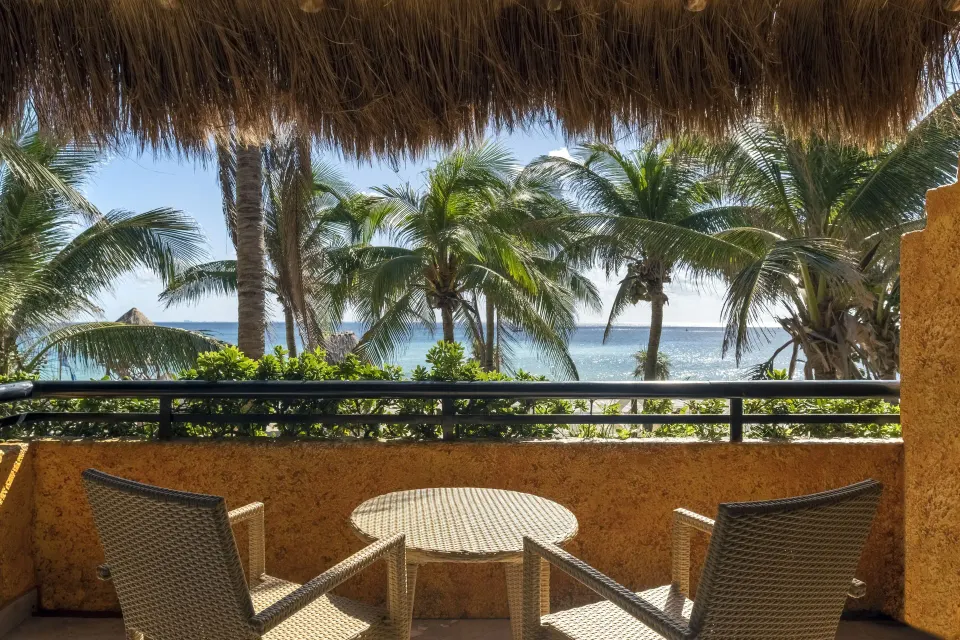 Balcony view from a Junior Suite Oceanfront at Iberostar Waves Tucán showing palm trees and the ocean.