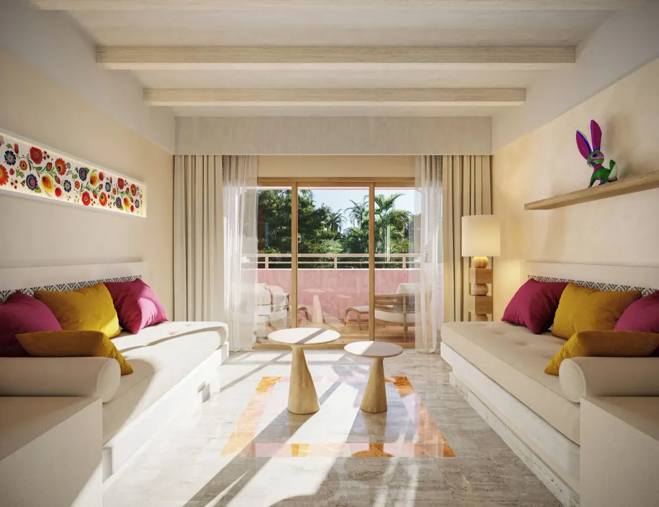 Junior suite living area with twin sofas and balcony at Iberostar Waves Tucán