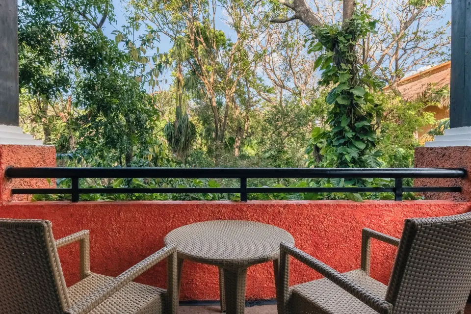 Private balcony with table and chairs overlooking trees at Iberostar Waves Tucán
