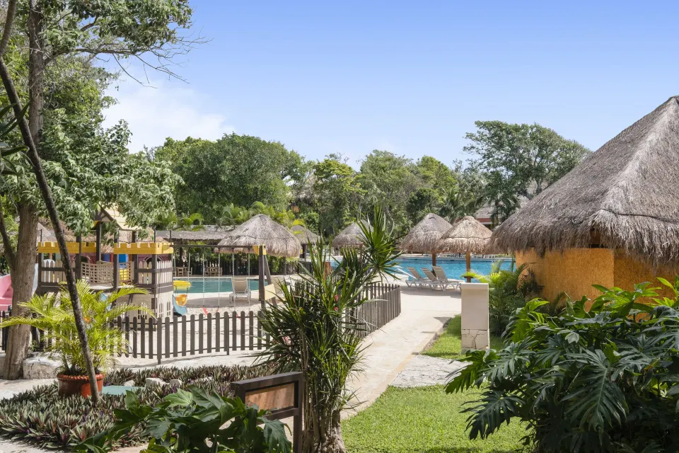 Resort pool and palapa roofs seen from a Premium Room near pool at Iberostar Waves Tucán