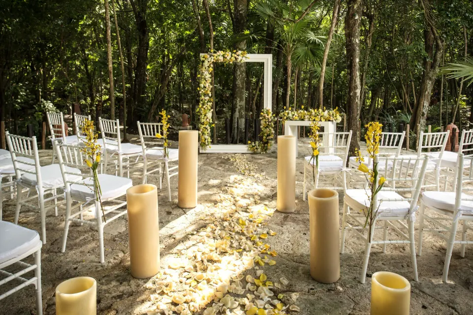 Forest wedding aisle with chairs and pillar candles at Iberostar Waves Tucán.