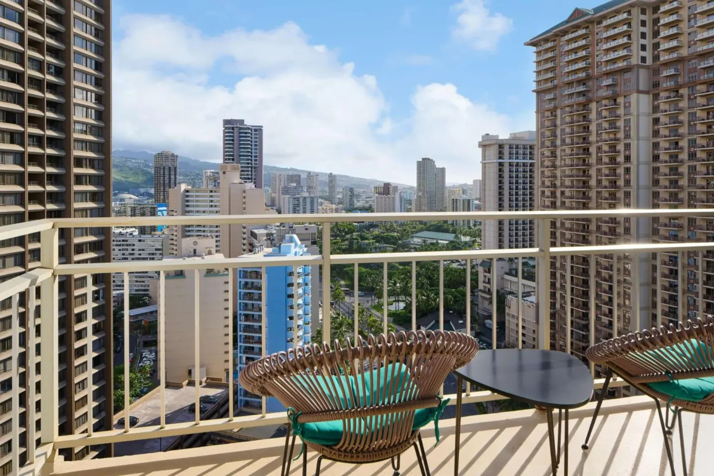 High-floor balcony seating faces Honolulu towers and mountains at Ilikai Hotel.