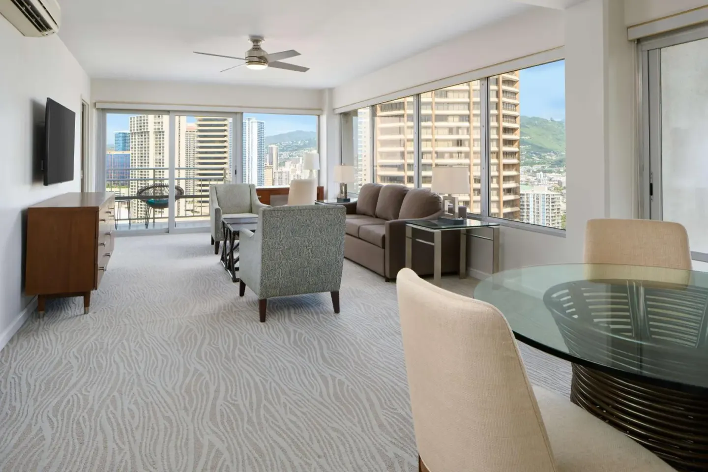 Bright living area with city views and dining table at Ilikai Hotel.