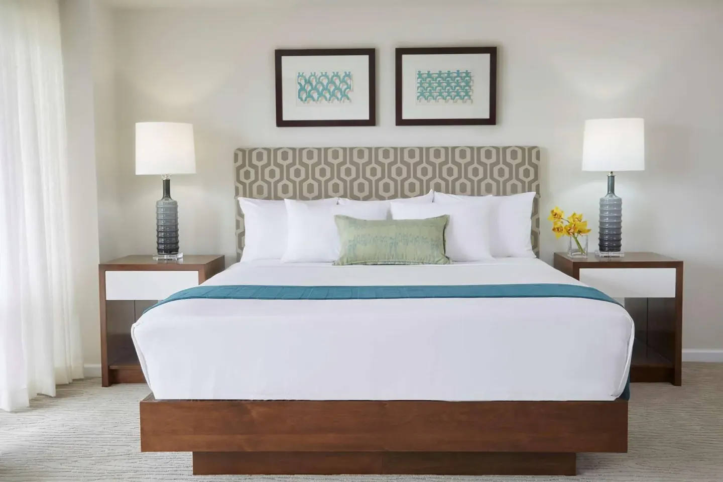 King bed with patterned headboard and bedside lamps at Ilikai Hotel.
