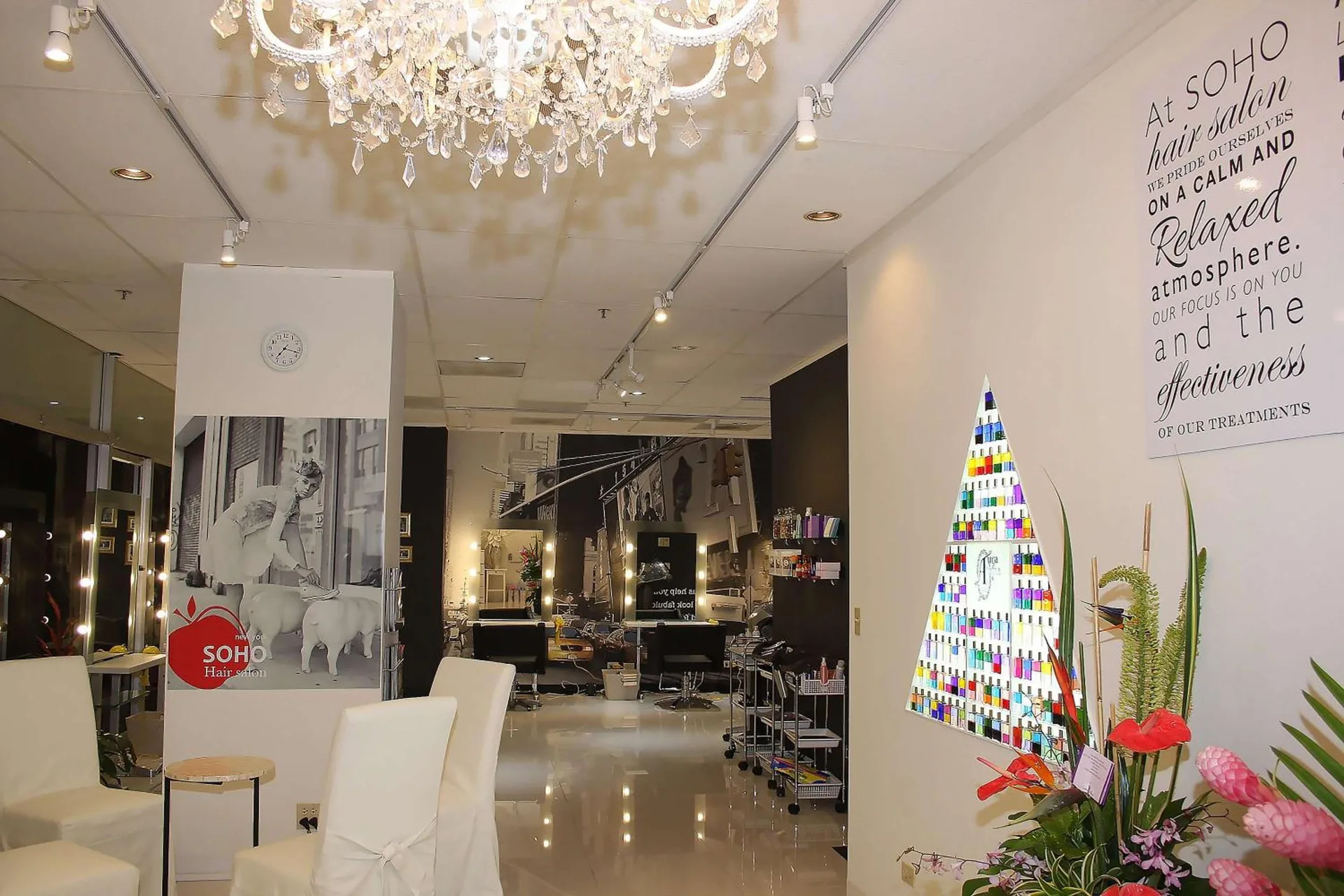 Hair salon interior with chandelier, styling stations, and flower display at Ilikai Hotel.