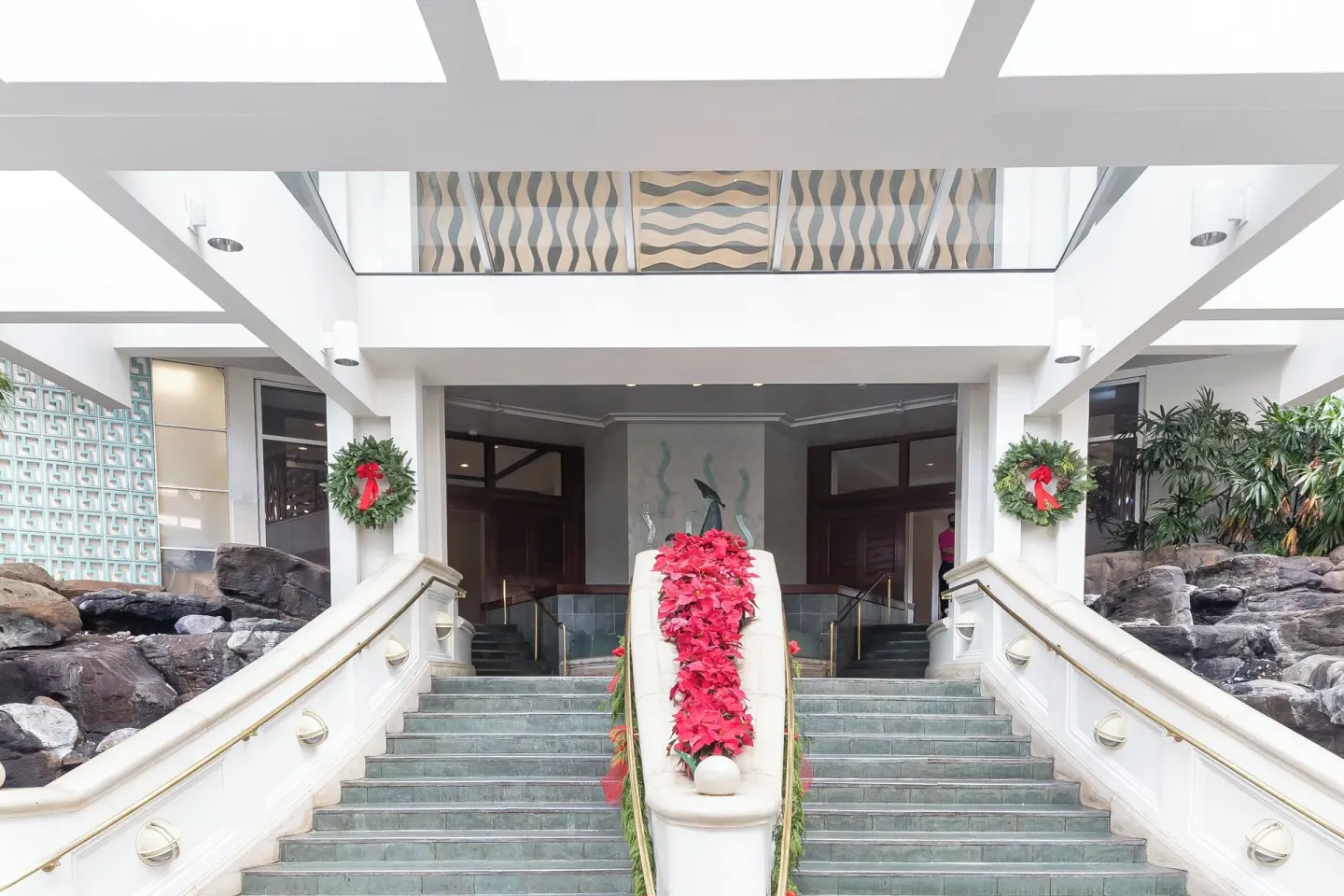 Holiday wreaths and red poinsettia decor on the main stairway at Ilikai Hotel.