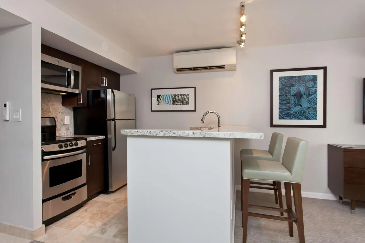 Suite kitchenette with island, stools, stove, microwave, and refrigerator at Ilikai Hotel.