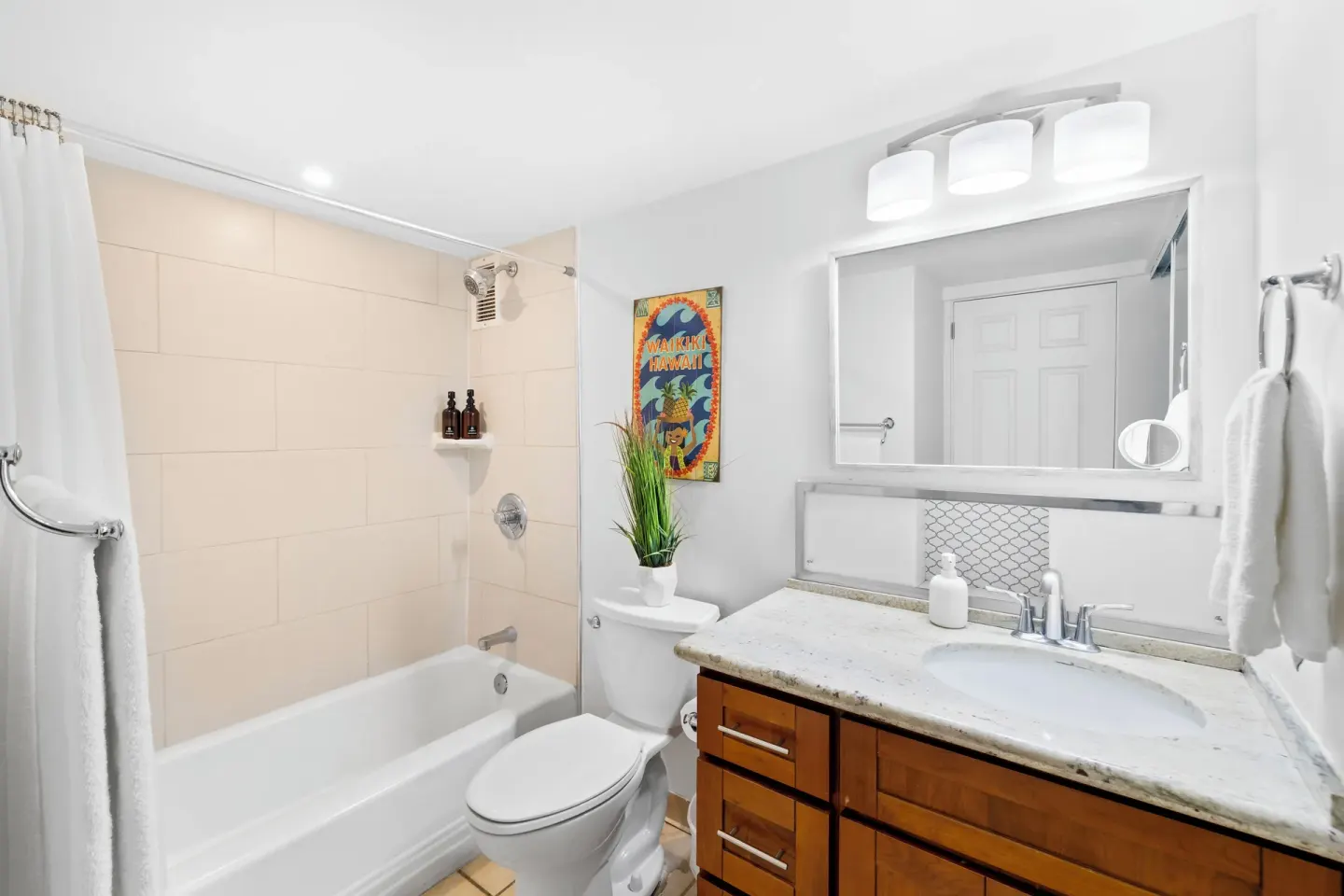 Bathroom with tub shower and vanity in a Standard Apartment at Ilikai Hotel.